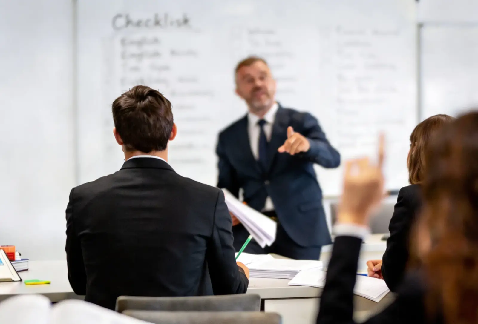 Sesión interactiva de capacitación de idiomas para empresas con un instructor corporativo y un pizarrón de checklist.