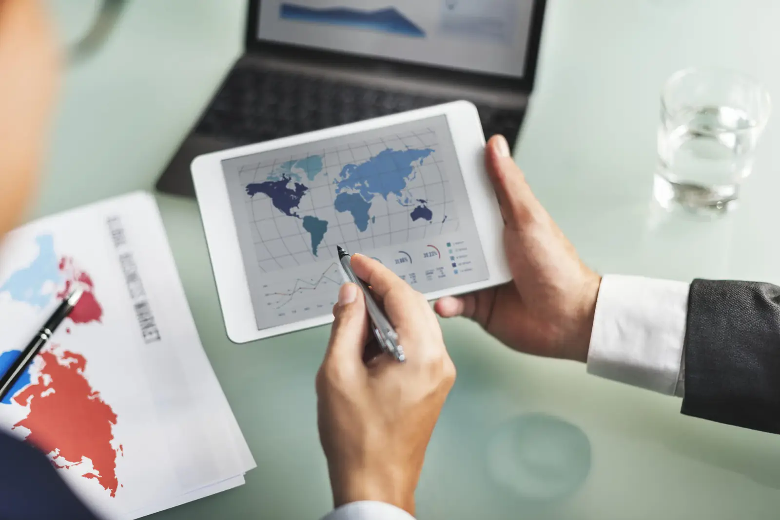 Directivo analizando mapas de comercio global y estrategias de nearshoring en mexico usando una tableta en su oficina.