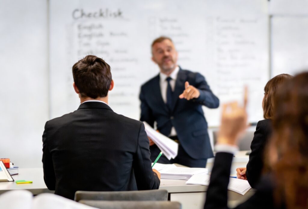 Sesión interactiva de capacitación de idiomas para empresas con un instructor corporativo y un pizarrón de checklist.