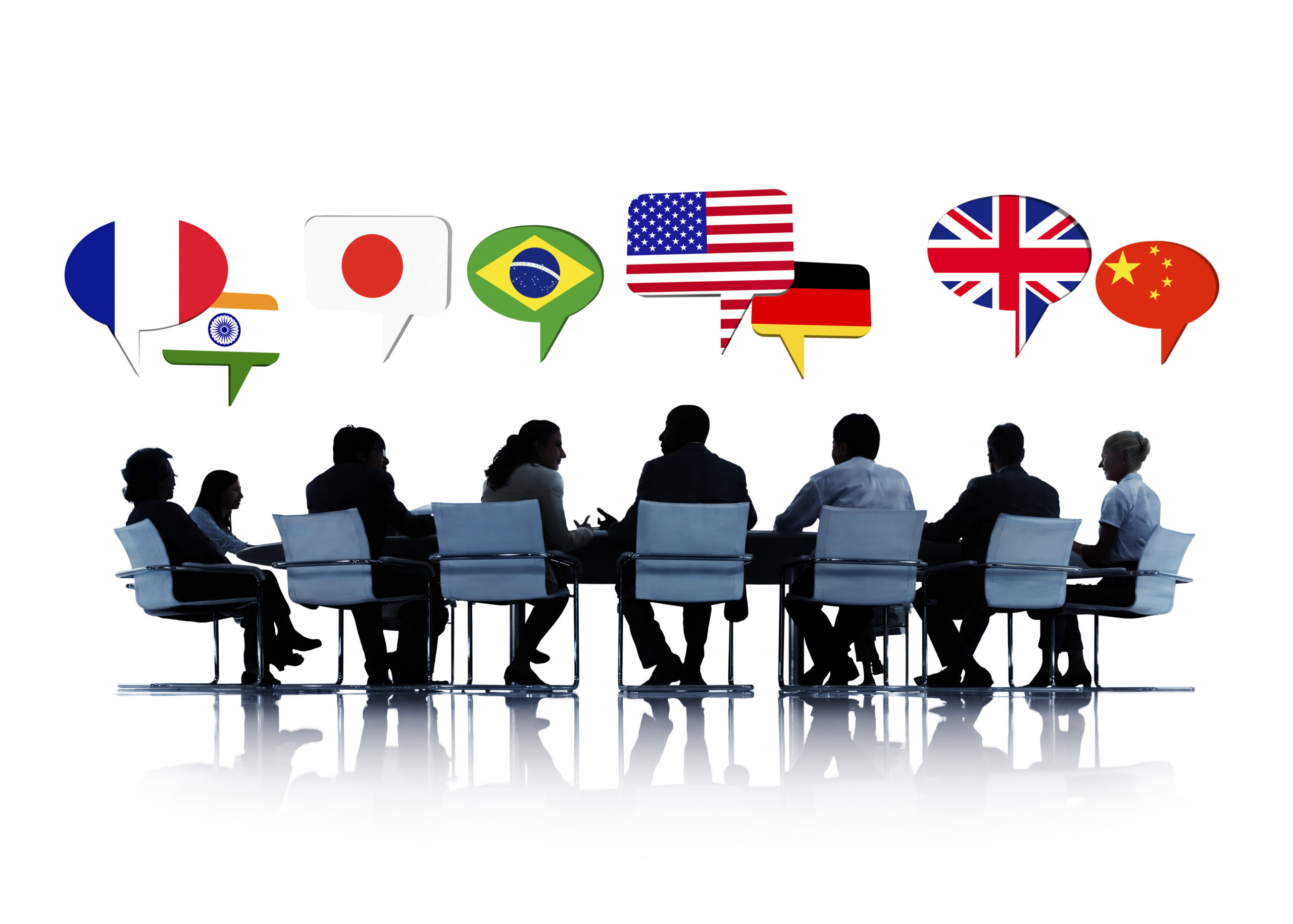 Silueta de un equipo corporativo en una mesa redonda, representando la formación lingüística corporativa y la inteligencia cultural para negociaciones internacionales exitosas, con burbujas de diálogo que muestran banderas internacionales de Francia, India, Japón, Brasil, EE. UU., Alemania, Reino Unido y China.