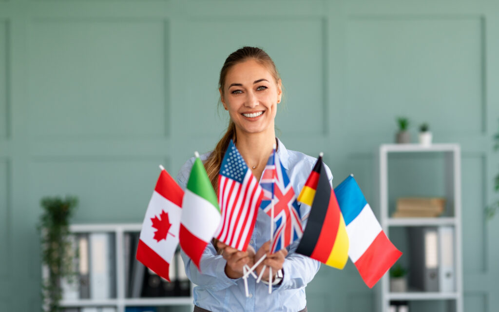 Una profesionista corporativa en un entorno multicultural rodeada de banderas de diferentes países, representando la comunicación global requerida por el nearshoring.
