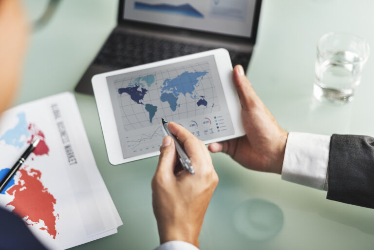 Directivo analizando mapas de comercio global y estrategias de nearshoring en mexico usando una tableta en su oficina.
